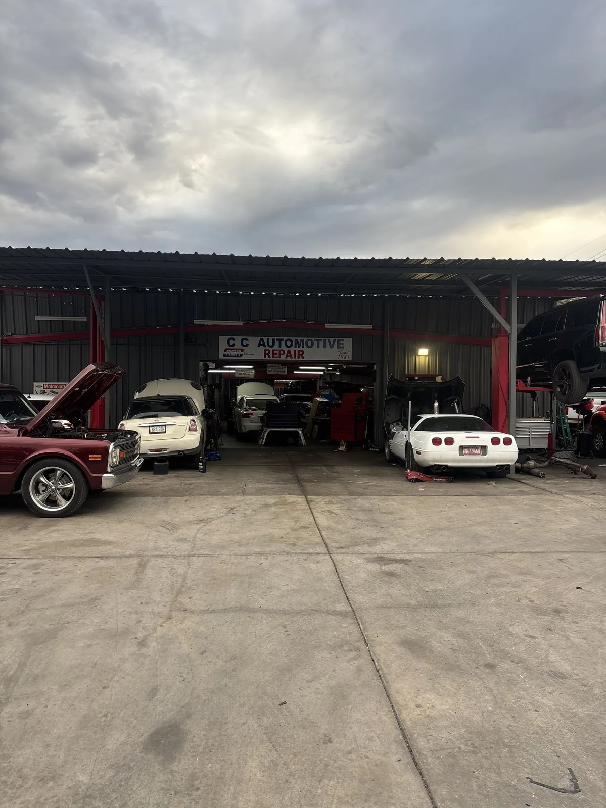 C.C. Automotive Repair shop exterior with bay doors open